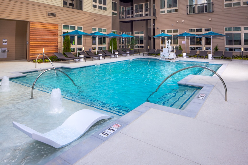 pool, water feature with immersed chaises, and seating under umbrellas south alex luxury apartments alexandria va