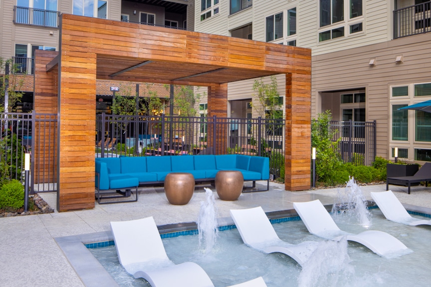 water feature with immersed chaises and pergola with lounge seating in courtyard