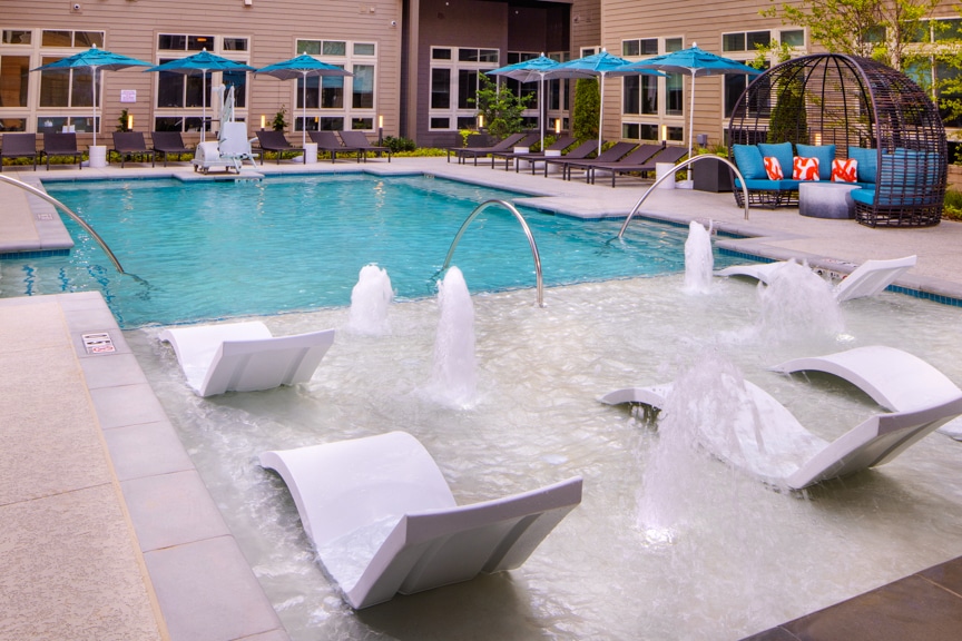 swimming pool with water feature, immersed chaises, and seating areas south alex luxury apartments alexandria va